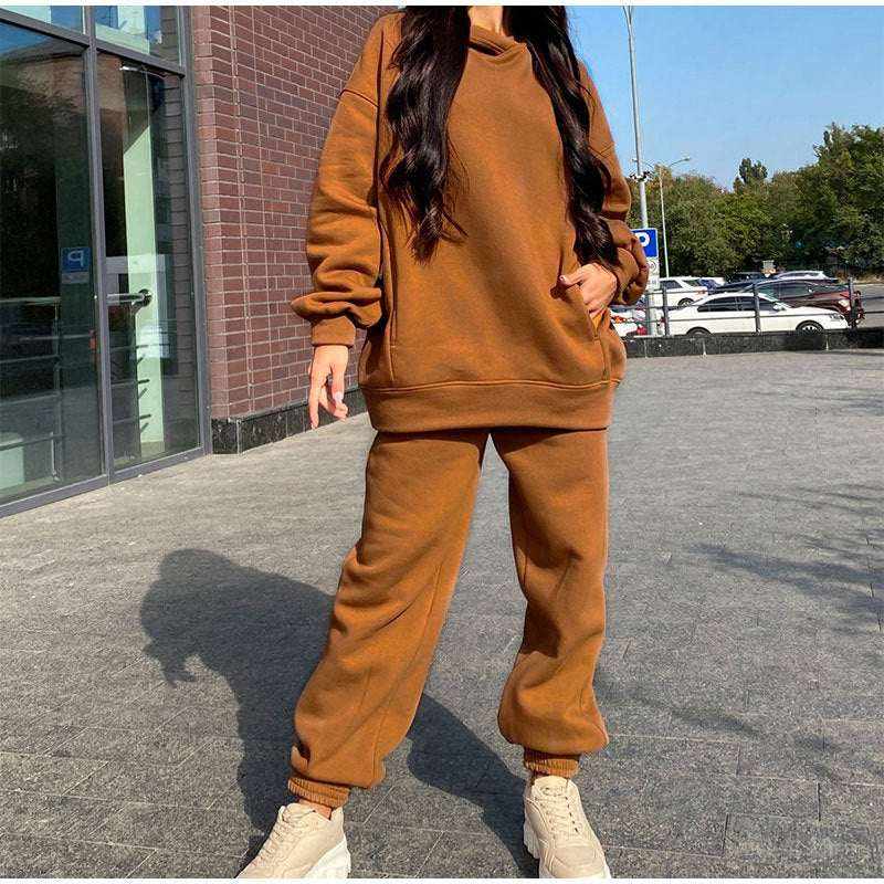 Woman wearing brown oversized sportswear tracksuit with beige sneakers outdoors