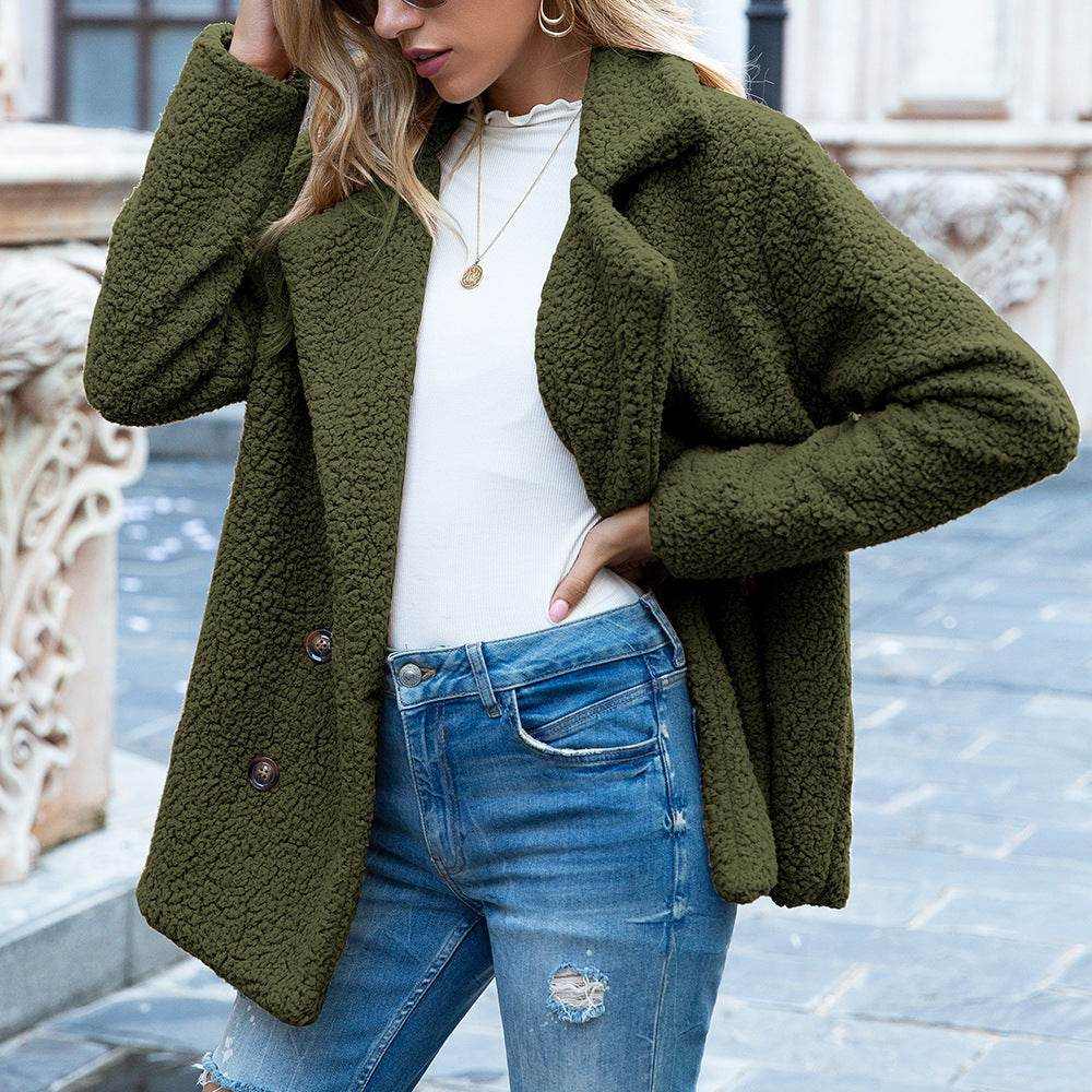Woman wearing olive green fluffy winter coat jacket with buttons and blue jeans outdoors