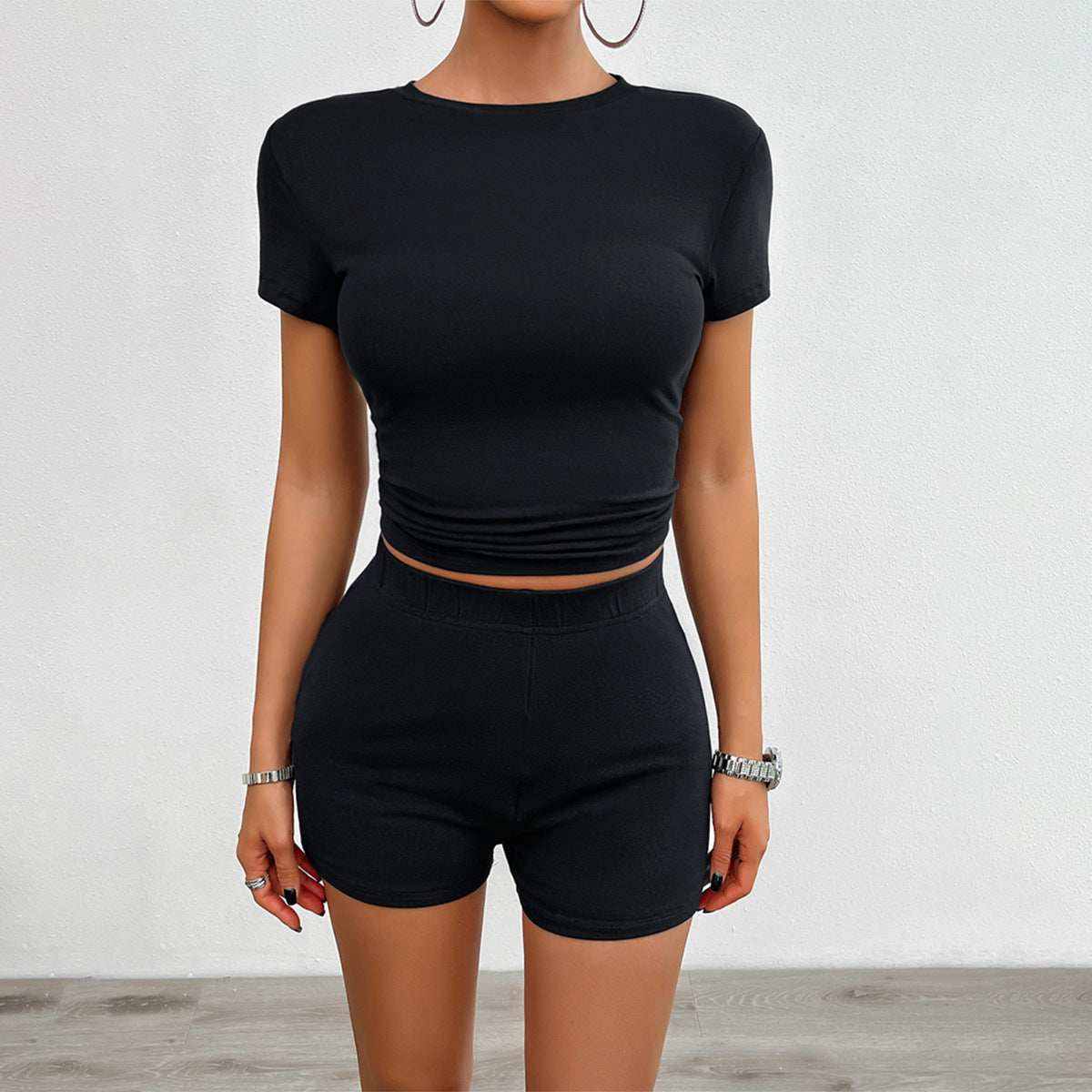 Woman wearing black 2Pcs short-sleeved crop top and matching shorts set