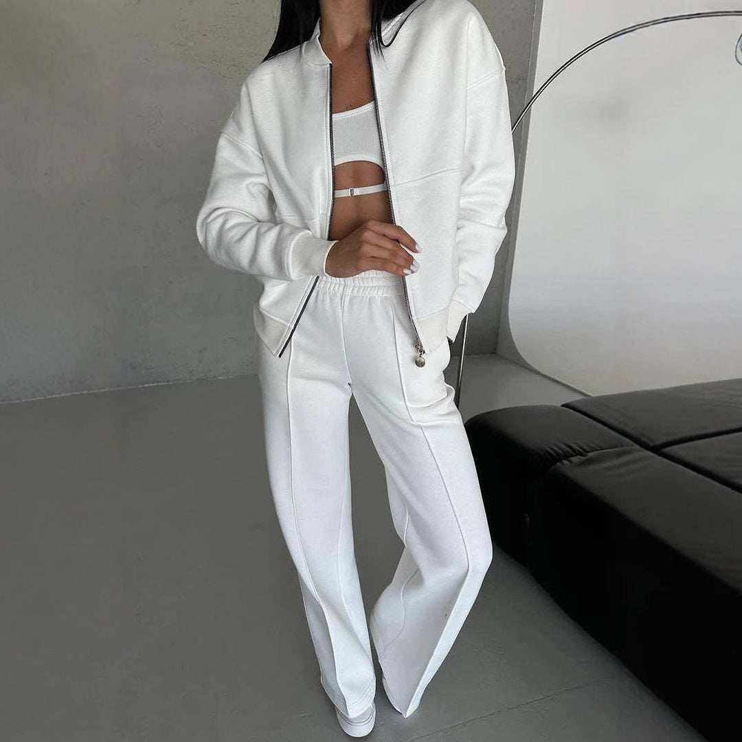 Woman wearing white leg pants two-piece set with zip-up jacket and wide-leg pants in minimalist room