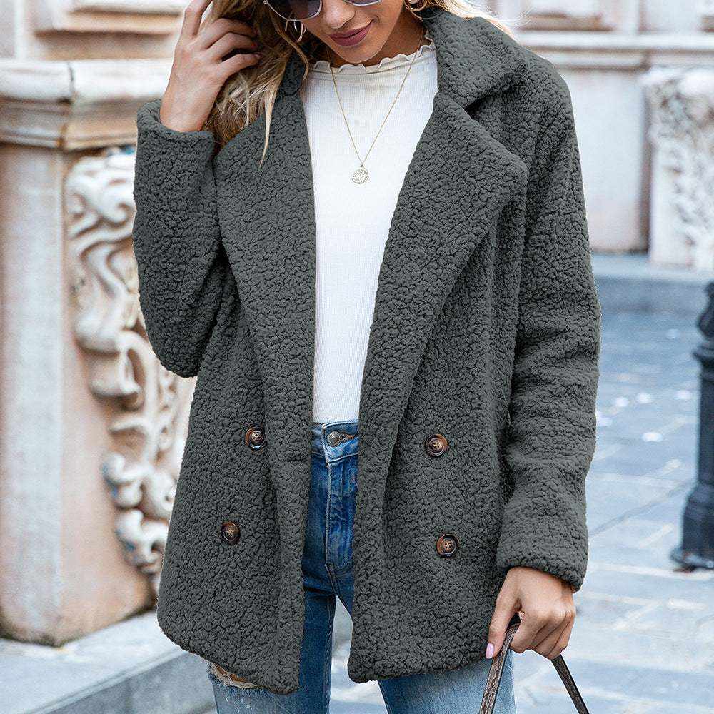 woman wearing dark gray fluffy coat winter jacket with buttons and blue jeans outdoors