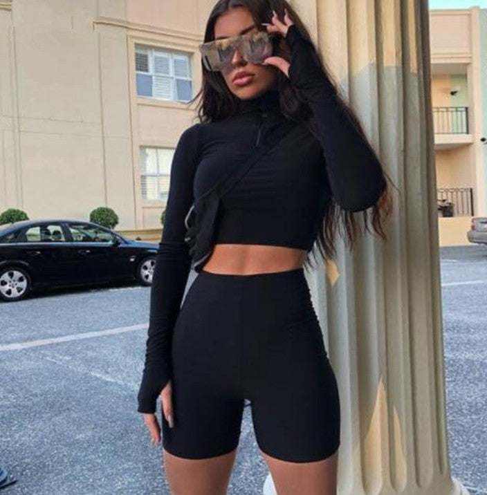 woman wearing black leggings sexy suit with long sleeves and sunglasses standing outdoors