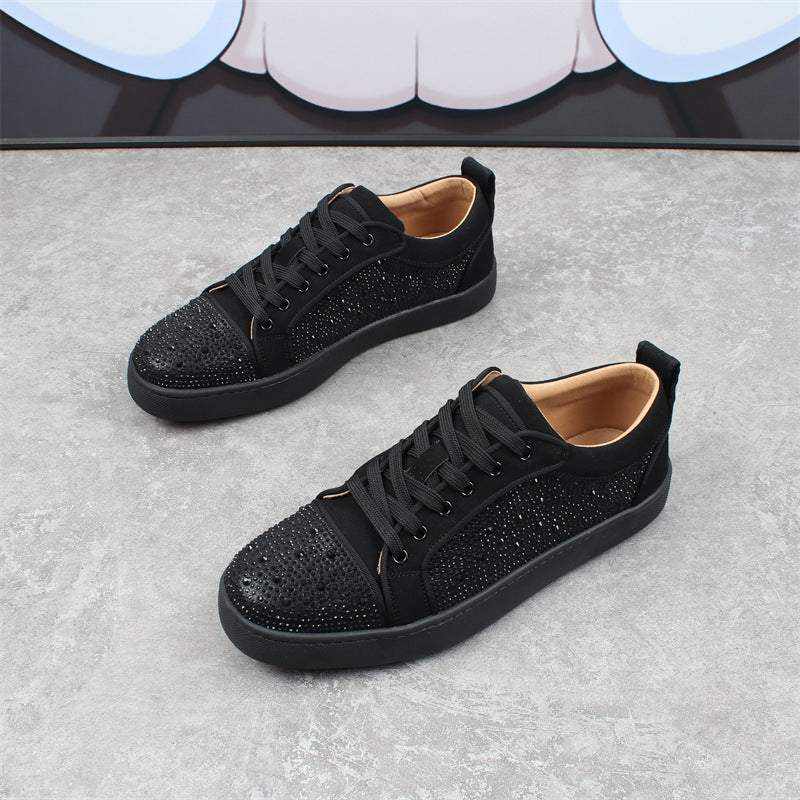 Black studded Red Bottom Sneakers with flat soles on gray floor background