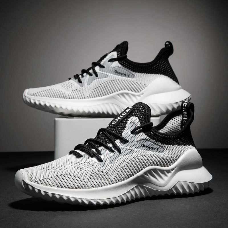 Lightweight black and white Flying Woven Shoes with breathable mesh upper and textured sole displayed on a gray background